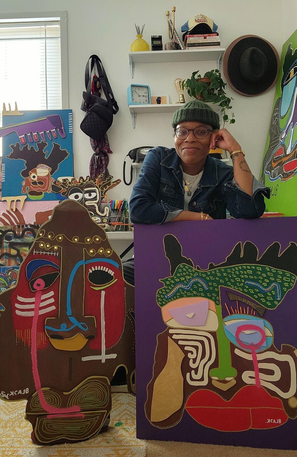 Photo of Brittany Mona surrounded by her artwork